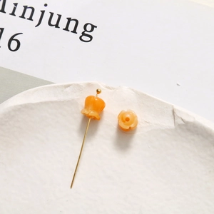 Makroaufnahme von Maiglöckchen-Anhänger und Perle aus Harz für DIY-Schmuck in Orange