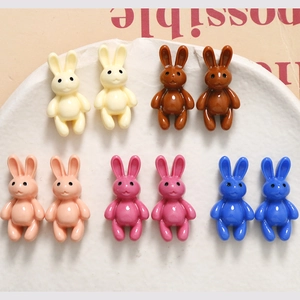 Macro shot of 10 colorful 3D resin rabbit charms for DIY jewelry making on white tray