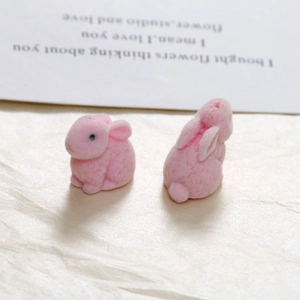 Detail of pink flocked cartoon bunny resin charms with soft matte texture for DIY crafts