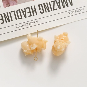 Detailweergave van de eenhoorn bedeltjes in lichtgeel voor DIY sieraden maken