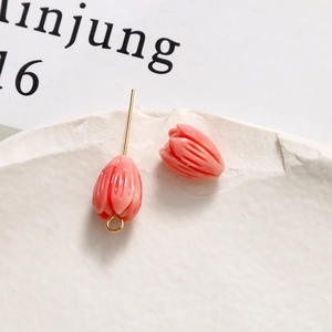 Macro detail of tulip flower beads in macaron pink with gold charms for jewelry making