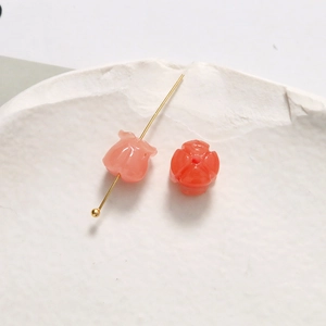 Makroaufnahme von rosa Maiglöckchen-Harzperlen mit goldenen Stiften für DIY-Schmuck