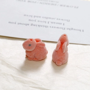 Close-up of pink flocked rabbit charms showing soft fuzzy texture and DIY threading holes