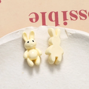 Detail of cream yellow resin bunny pendants showing both front and flat back surfaces