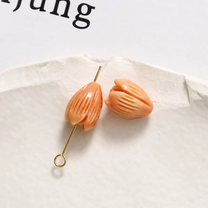 Macro shot of tulip-shaped beads in pastel pink for DIY earring and jewelry making
