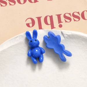 Macro shot of 3D blue resin rabbits for DIY crafts on white stone and kraft paper