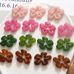 Détail de breloques fleurs en résine colorée avec anneau pour création de bijoux DIY