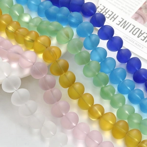 Macro view of matte translucent colorful glass beads arranged in rows for DIY jewelry