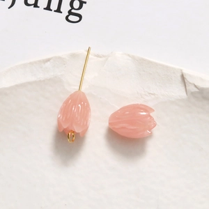 Macro detail of pink tulip resin beads for DIY jewelry with gold metal loop findings
