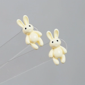 Detailed view of 3D resin rabbit charms for DIY crafts on a clear acrylic display stand