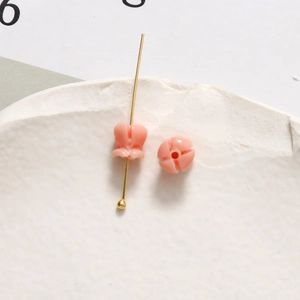 Makro-Detail des rosa Maiglöckchen-Anhängers mit goldenem Stift für DIY-Schmuckherstellung