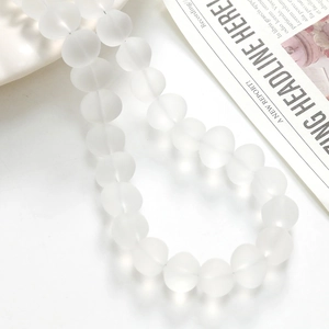 Close-up of frosted semi-transparent white glass beads for DIY jewelry making