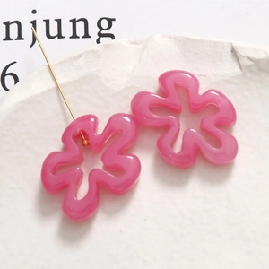 Gros plan de breloques fleurs évidées en résine rose avec tige pour bijoux DIY