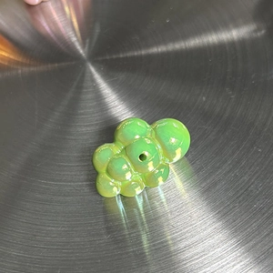 Vue macro d'un pendentif nuage iridescent vert clair avec un fini perlé élégant