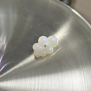 Détail de la breloque nuage blanc nacré avec trou pour la création de bijoux DIY