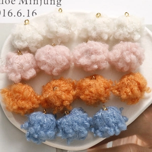 Macro detail of plush lamb wool charms in four colors with gold metal rings for DIY jewelry