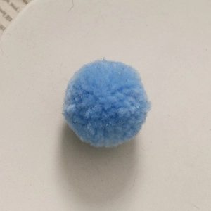 Macro-opname van een lichtblauwe handgemaakte DIY pluchen pompon met zachte textuur