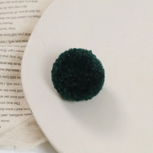 Macro-opname van een donkergroene pluizige pompon voor DIY-sieraden en decoraties