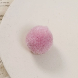 Close-up van een zachte roze pompon voor doe-het-zelf sieraden en creatieve projecten