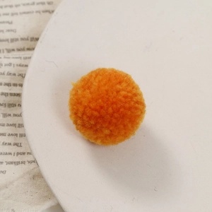 Gedetailleerde close-up van een feloranje pompon met dichte wolvezelstructuur