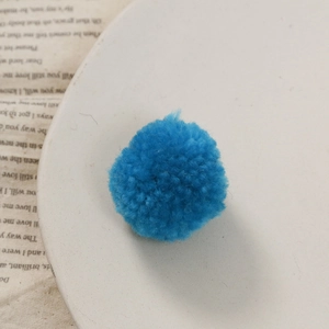 Gedetailleerde close-up van een felblauwe wollen pompon voor DIY-knutselaccessoires