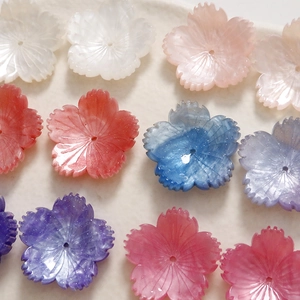 Macro shot of glitter acetate cherry blossom charms with center holes for DIY jewelry