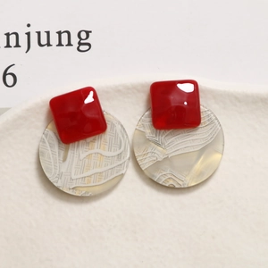 Detail of red square resin and circular printed map texture earring for DIY jewelry