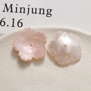 Macro detail of pearlescent flower charms with delicate texture for DIY jewelry making
