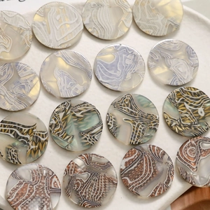 Macro detail of polished round acetic acid acrylic pieces with marble and tiger textures