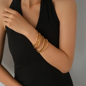 Minimalistisches Set aus goldfarbenen Titanstahl-Armbändern mit Perlen- und Bambus-Design