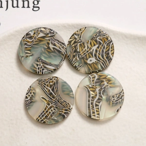 Macro detail of round zebra stripe acetate acrylic jewelry pendants on white stone