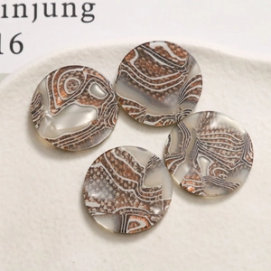 Macro shot of circular brown marble acetate charms for jewelry making and DIY crafts