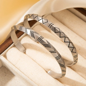 Detailed view of Nordic Viking rune bangles with geometric patterns in matte gold finish