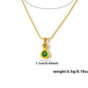 Dettaglio della collana infinity d'oro con smeraldo a goccia e ciondolo lettera F