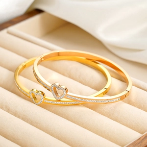 Elegante conjunto de brazaletes de corazón dorados con cristales en cojín de joyería