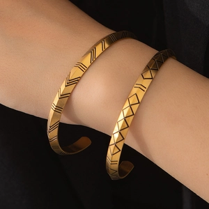 Norse Viking gold open cuff bracelet with engraved geometric runes on a wrist