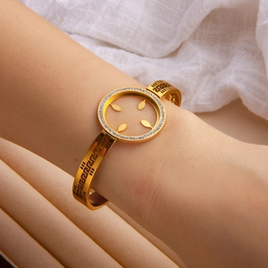 Close-up of golden bangle with crystal circle design and meander pattern on wrist