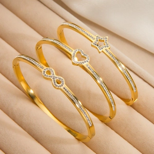 Set van drie goudvergulde roestvrijstalen armbanden met ster, hart en oneindigheidsteken