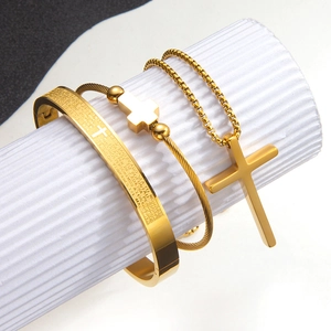 Conjunto de collar de cruz y pulsera con escrituras en acero dorado sobre soporte blanco