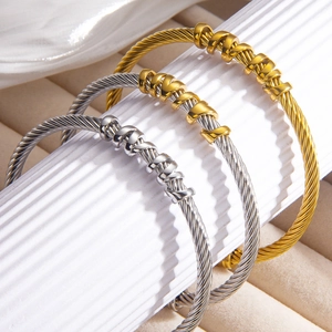 Detailed macro view of cable wire bangle bracelets in gold and silver stainless steel