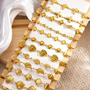 Detailansicht goldener Armbänder im Meeresstil mit Muschel- und Schmetterlingsanhängern
