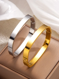 Close-up of gold and silver irregular square bracelets on a jewelry box display
