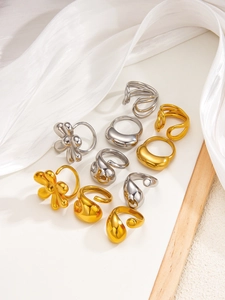 Detailed close-up of 18k gold and silver liquid metal flower rings on white display