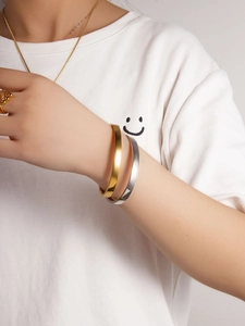 Detail showing minimalist gold and silver cuff bracelets with matching beaded ring