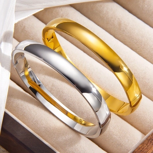 Minimalist high-polished 18k gold and silver stainless steel bangles in a jewelry box
