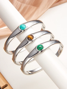 Détail de bracelets joncs en argent avec incrustations de turquoise oeil de tigre malachite