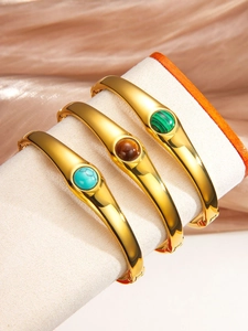 Détail de trois bracelets vintage dorés sertis de malachite, d'oeil de tigre et de turquoise