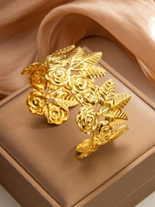 Detailed macro view of 18k gold plated bangle featuring embossed rose floral patterns