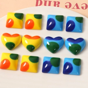 Retro colorful polka dot resin heart and square cabochons for DIY crafts on a white plate