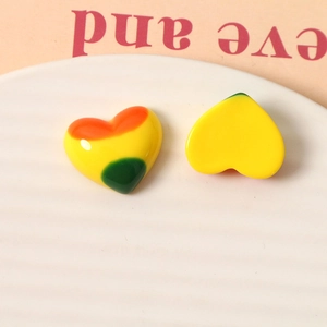 Detailed view of colorful heart-shaped resin charms on a ceramic plate for DIY accessories